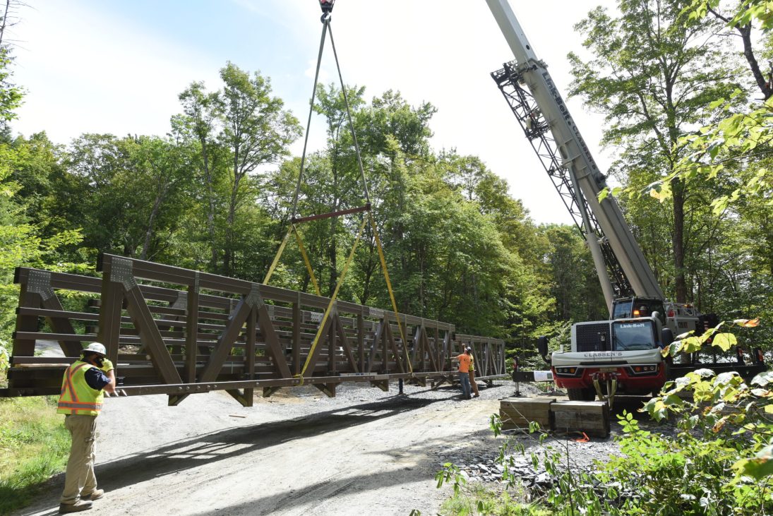 Link-Belt 120|HT setting the 80ft fibreglass footbridge over a ravine in Vermont
