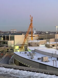 Liebherr LTM 1750 all-terrain crane with luffing jib rigged over Terminal E at snow-covered Boston Logan airport