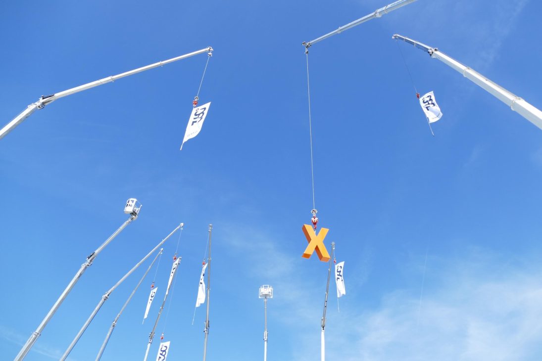 Böcker crane booms extended against a blue sky during demonstrations in Werne