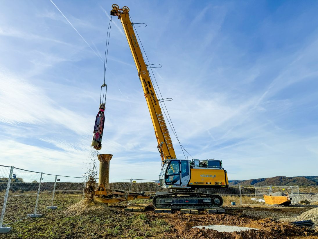 Casing machine mounted on the Sennebogen duty cycle crane driving drill pipe into the ground
