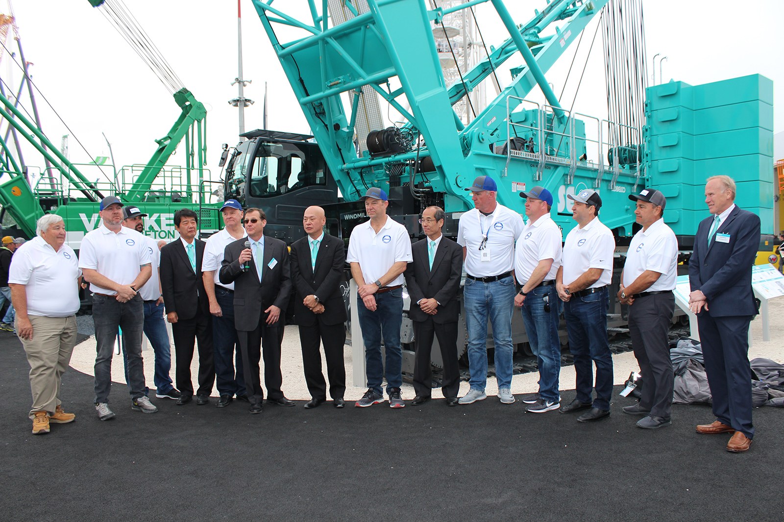 Kobelco and Bigge representatives marking an order for 19 crawler cranes at Bauma