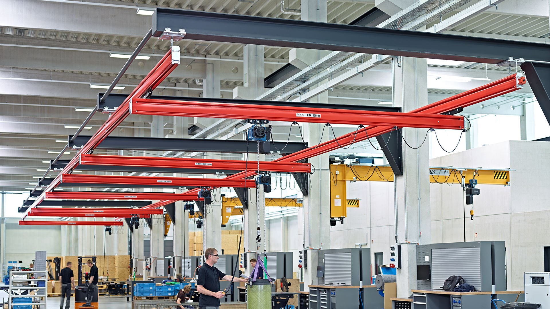 Demag KBK light crane systems with red aluminium girders installed in a production hall