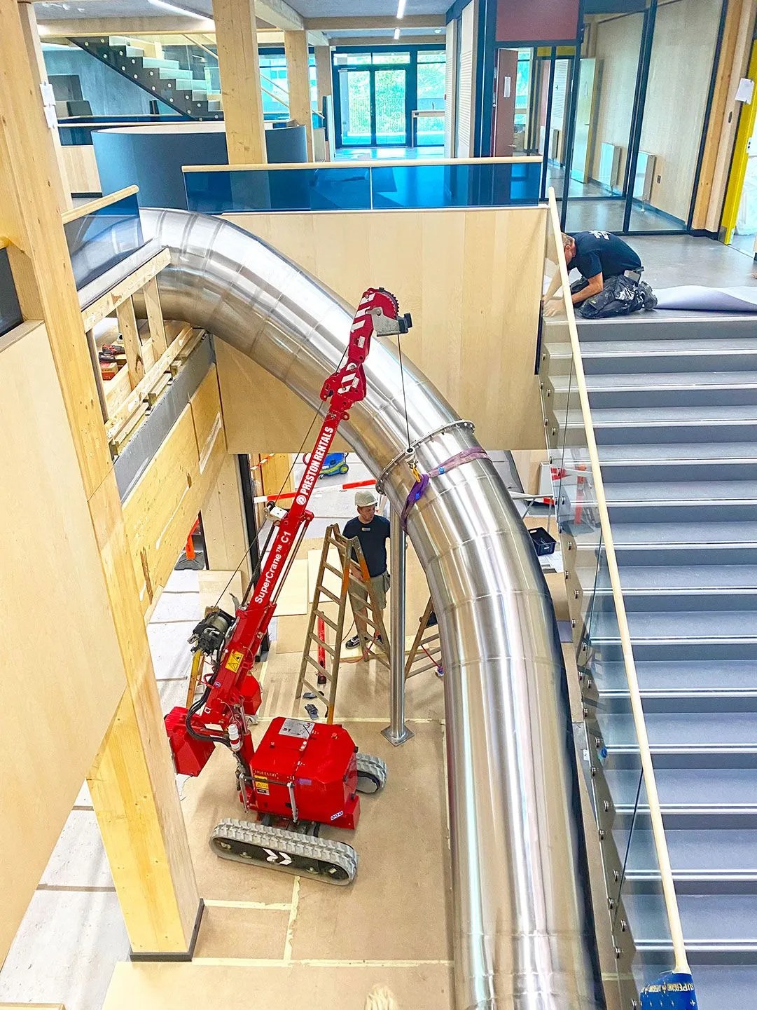 Hoeflon C1e mini crane and TC1 carrier positioned indoors during a slide installation