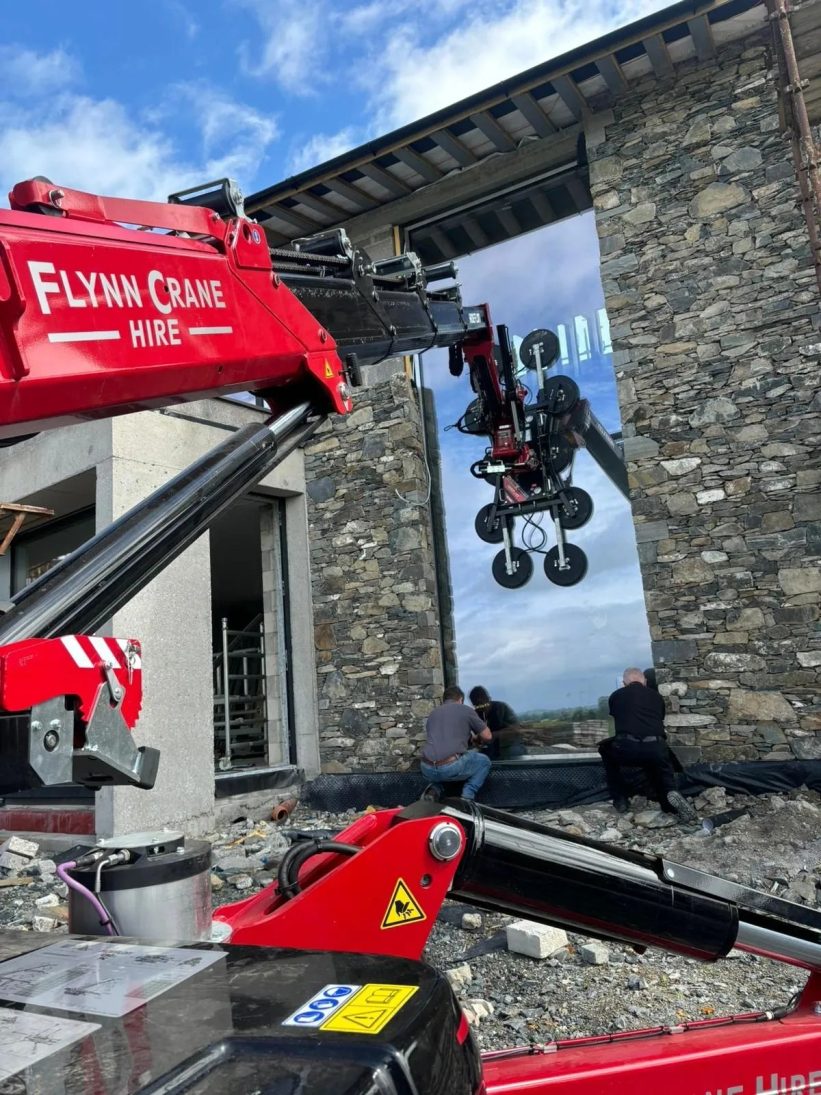 Hoeflon C30e with vacuum lifter placing a large glass panel in Tullamore