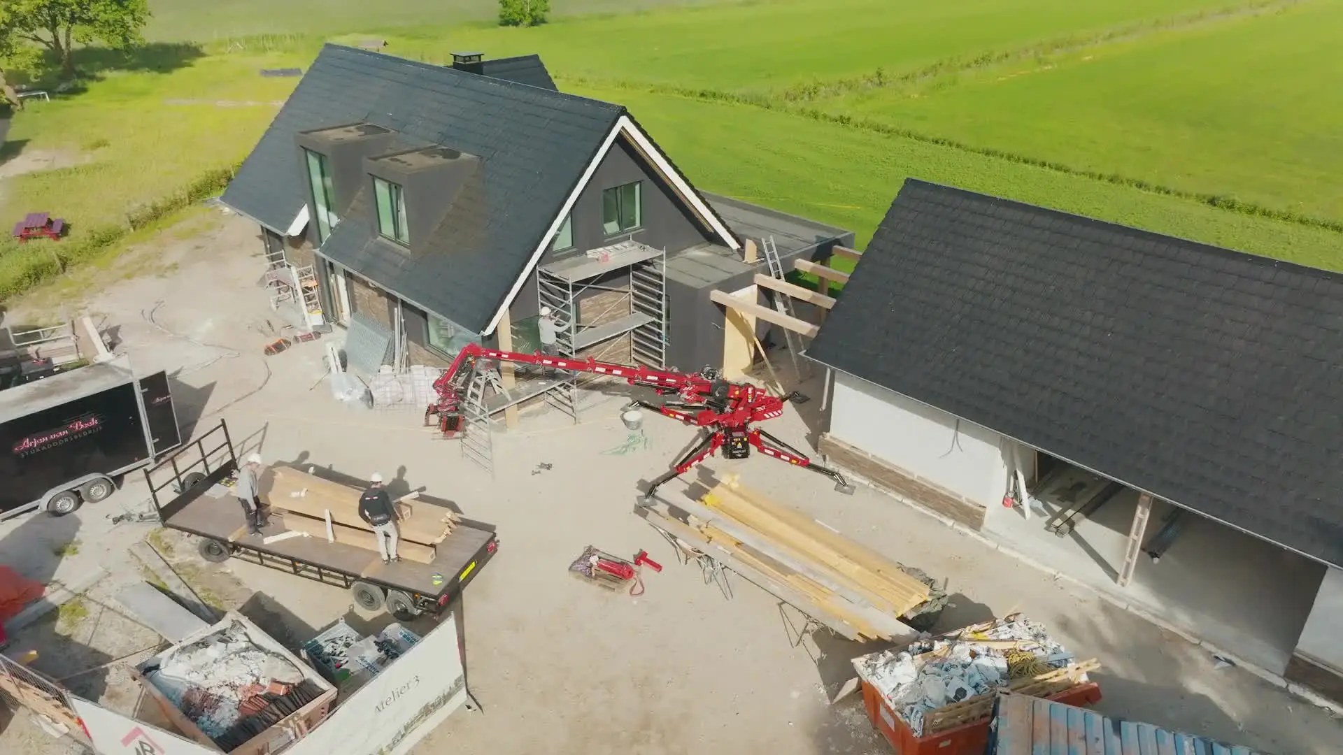 Aerial view of the Hoeflon C6e set up on outriggers beside a house under construction