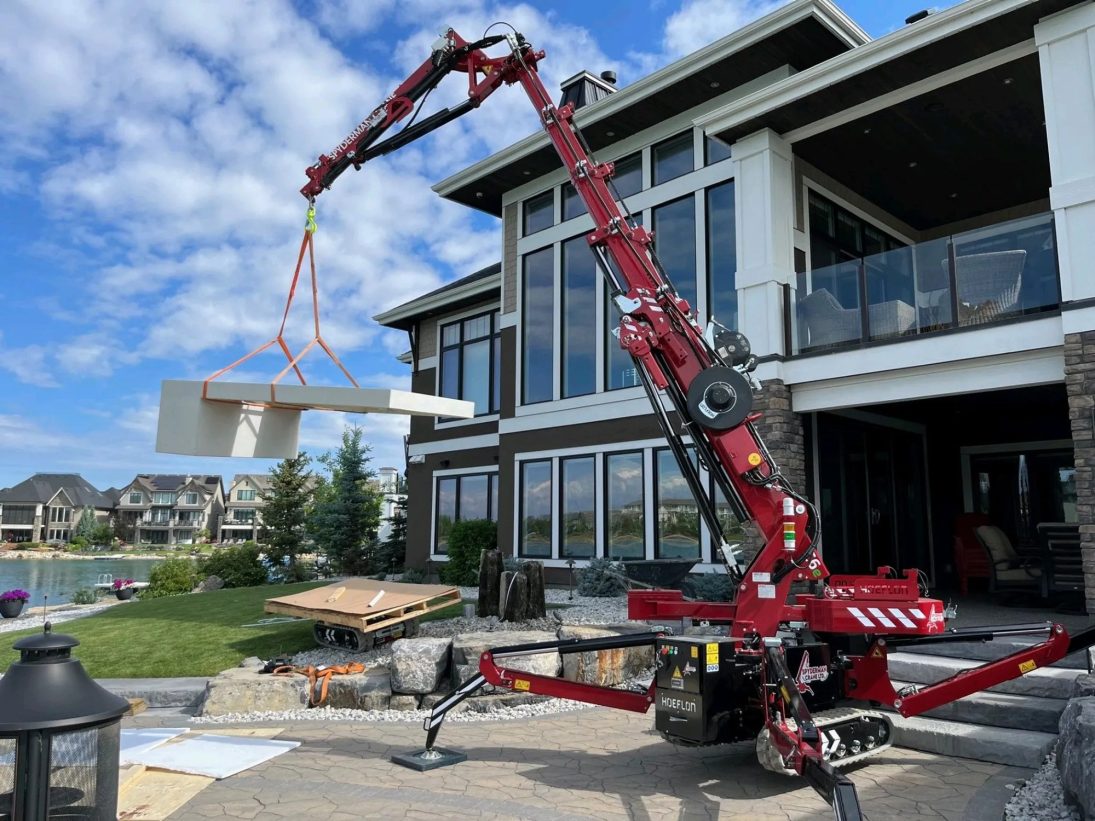 Hoeflon C6e compact crane set up on outriggers on a construction site