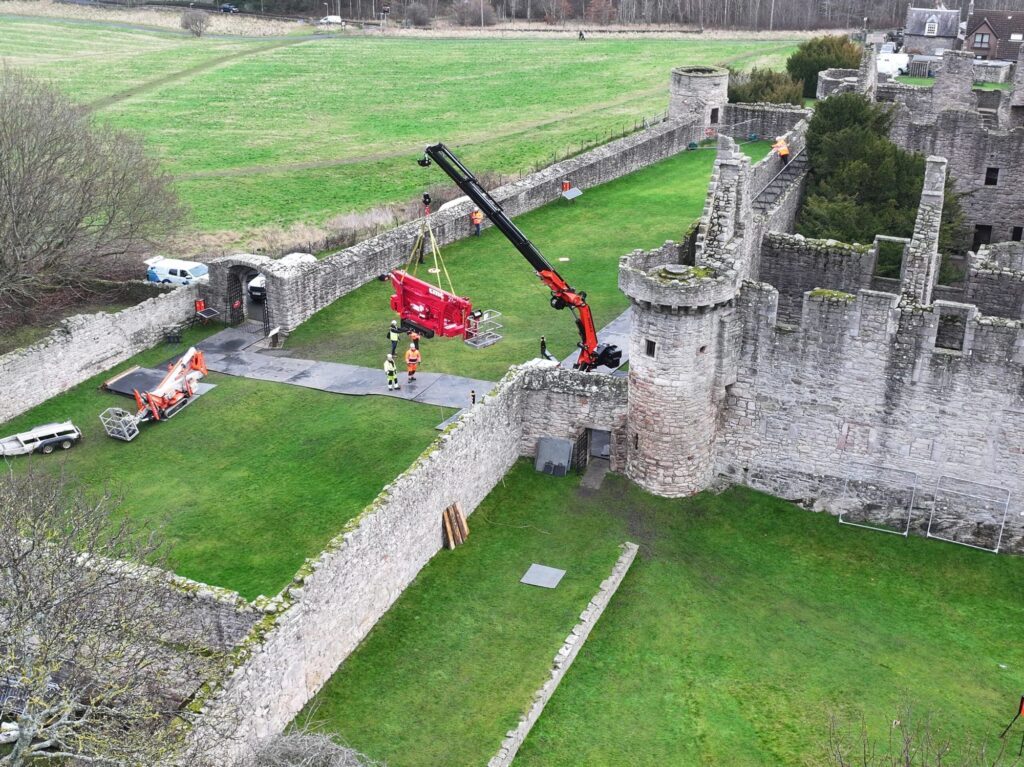 Jekko JF545.2 crawler crane passing the narrow medieval arch-gate at Craigmillar Castle