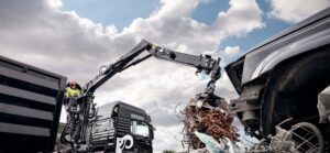 JONSERED recycling crane with grapple loading scrap metal into a truck body