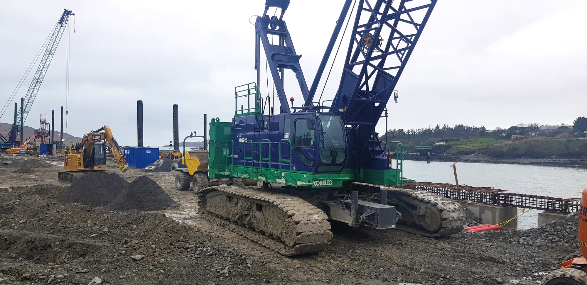Kobelco CKE1100G crawler crane handling tubular piles at Dinish Wharf
