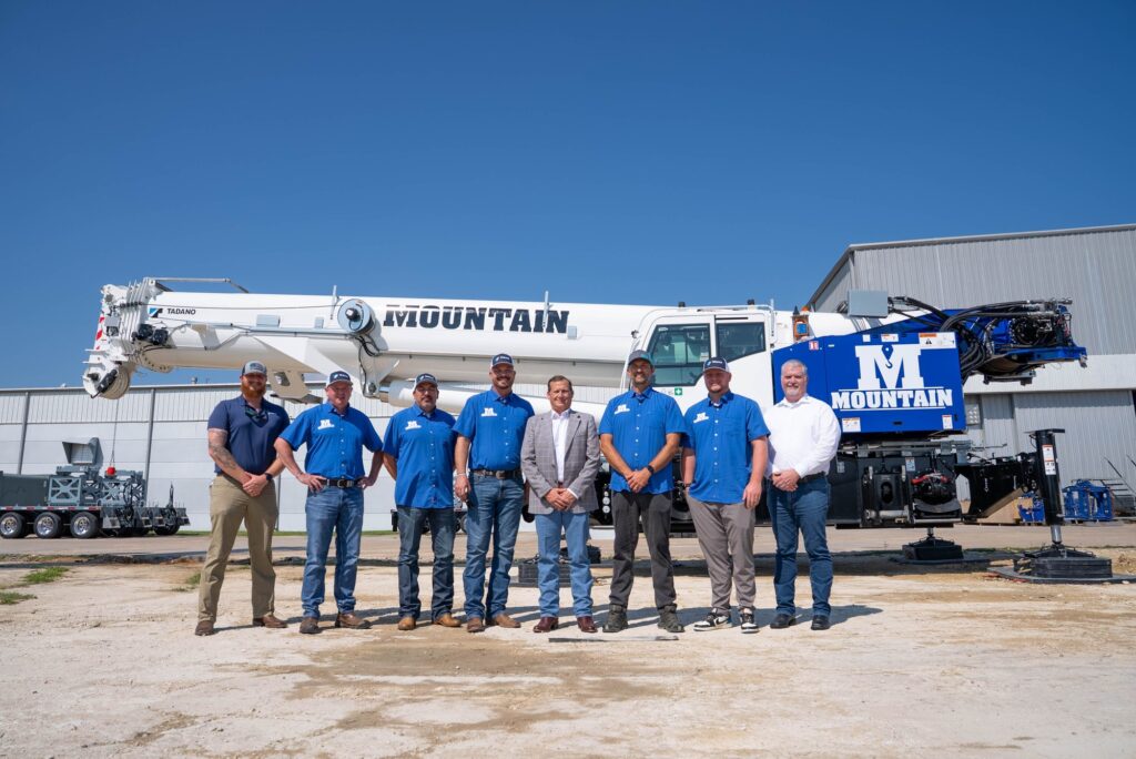Mountain Crane and Tadano staff in front of a Tadano rough terrain crane in Mountain livery