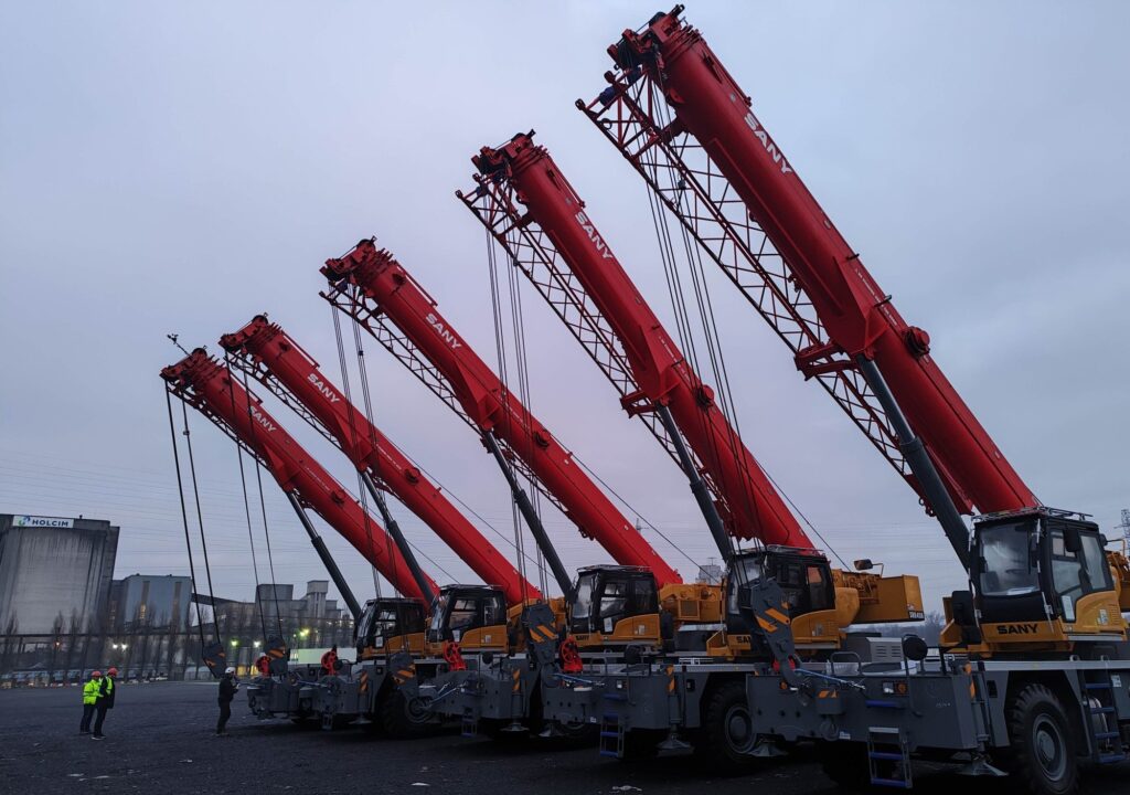 Five SANY rough terrain cranes with booms raised at a yard, the first SANY rough terrains working in Belgium