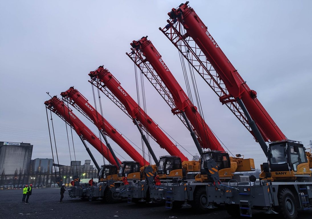 Five SANY rough terrain cranes with booms raised at a yard, the first SANY rough terrains working in Belgium