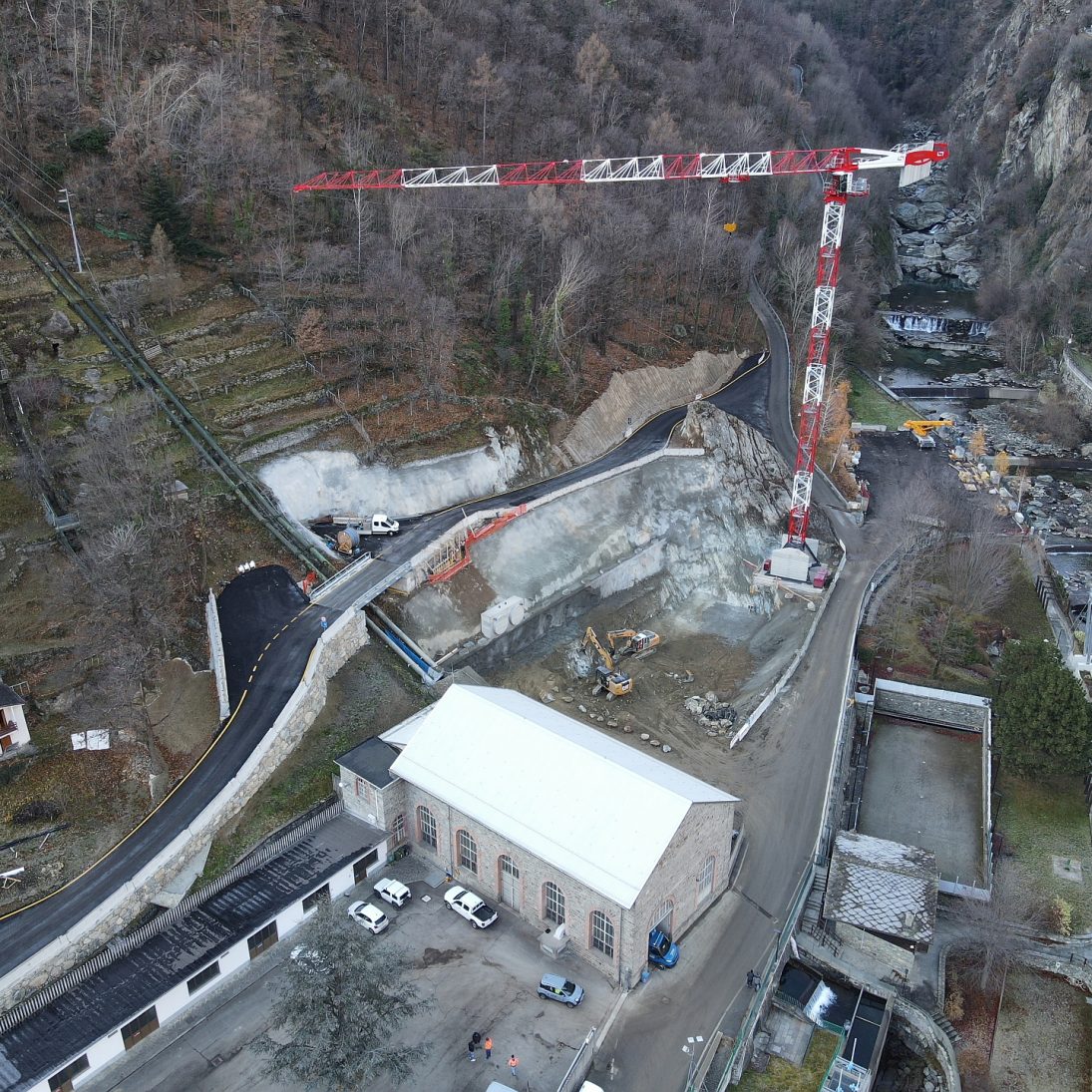 Aerial view of the Hone hydropower site with the Potain MDT 269 alongside the penstock excavation