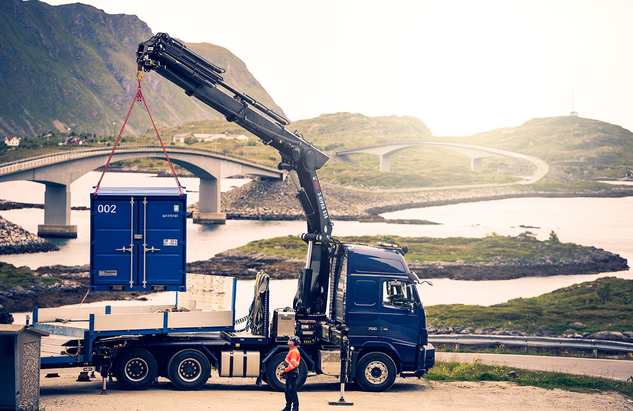 HIAB X-HiPro 638 loader crane lifting a site container from a truck bed
