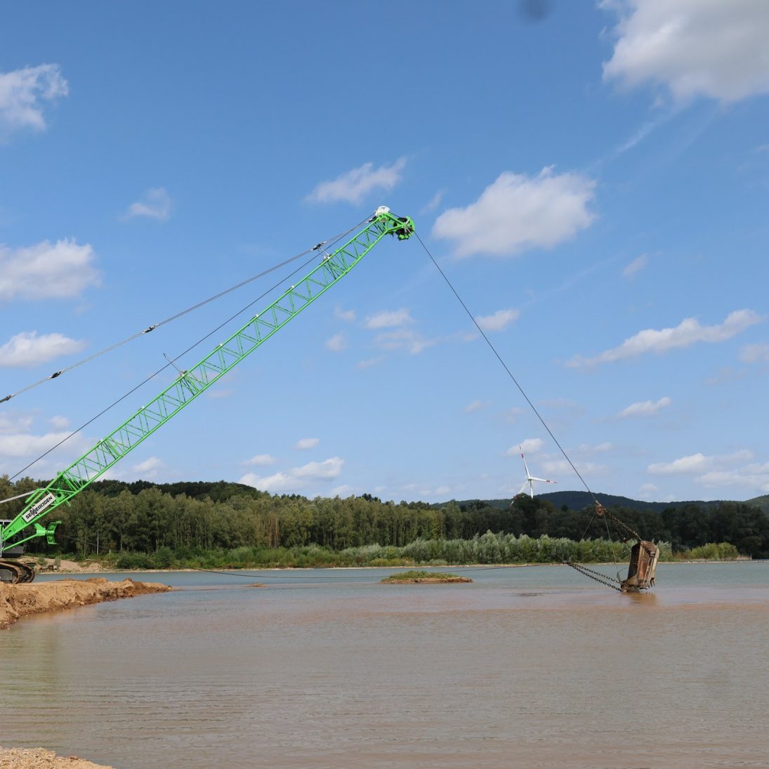 Dragline bucket of the Sennebogen 6100 being drawn towards the crawler crane