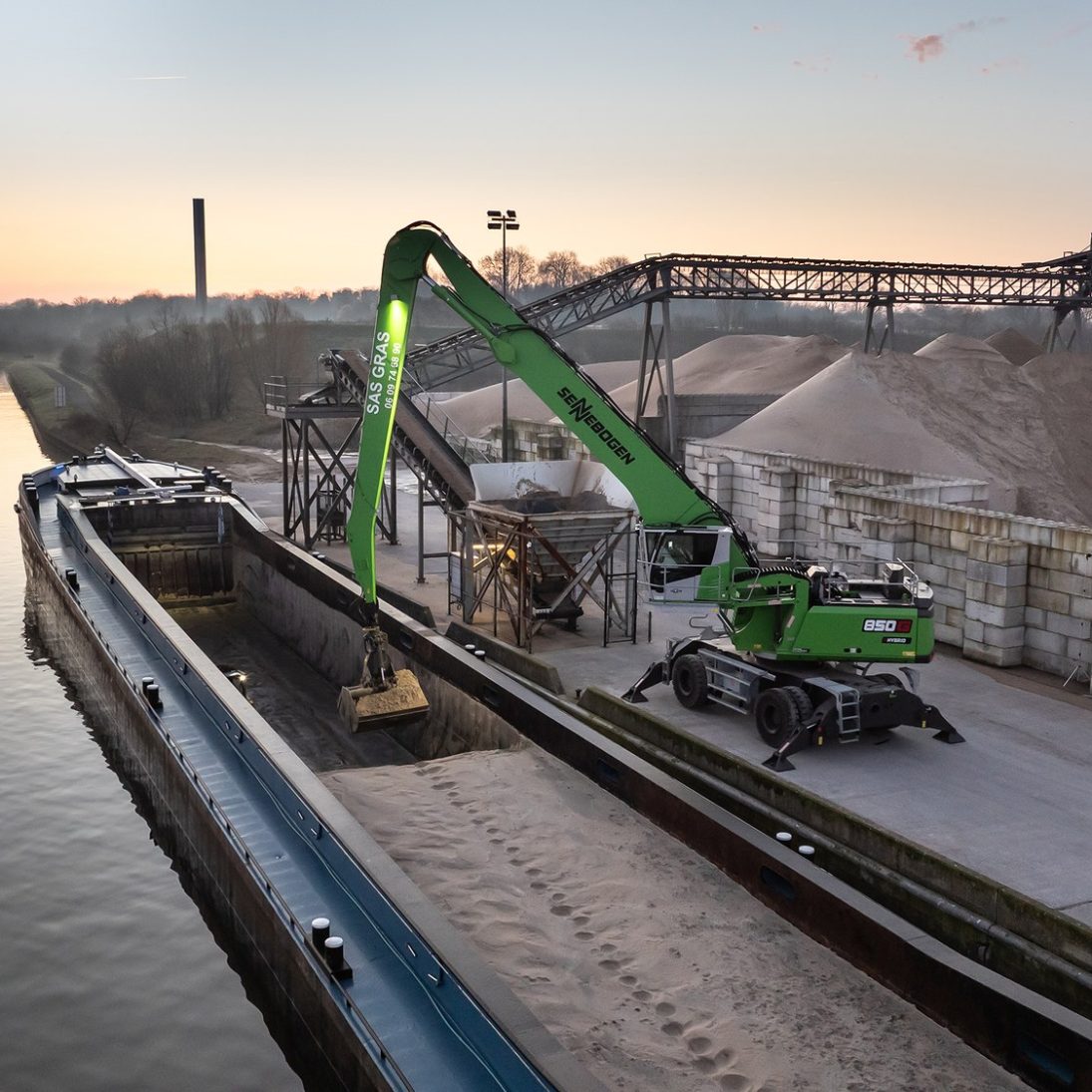 Sennebogen 850 G Hybrid with orange peel grab working at the quayside