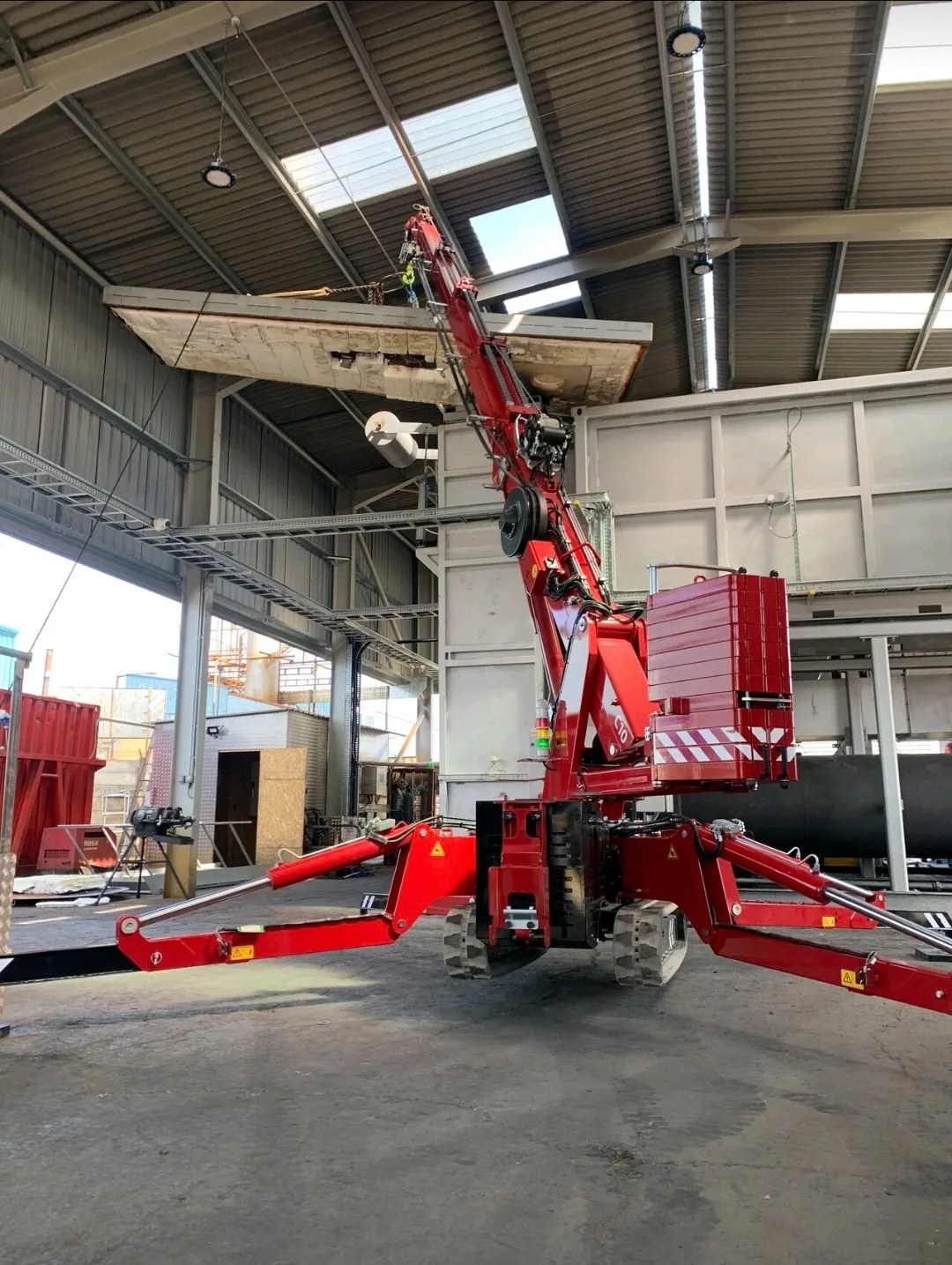 Hoeflon C10 compact crane set up on outriggers during an indoor lift