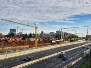 Spierings mobile tower cranes standing beside the A9 motorway widening works with traffic running past