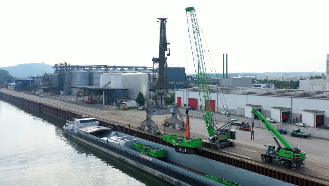 Tandem lift of a heavy machine component onto a barge deck at Straubing-Sand