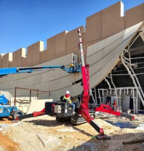 UNIC spider crane lifting a steel element on a restricted-access construction site in Riyadh
