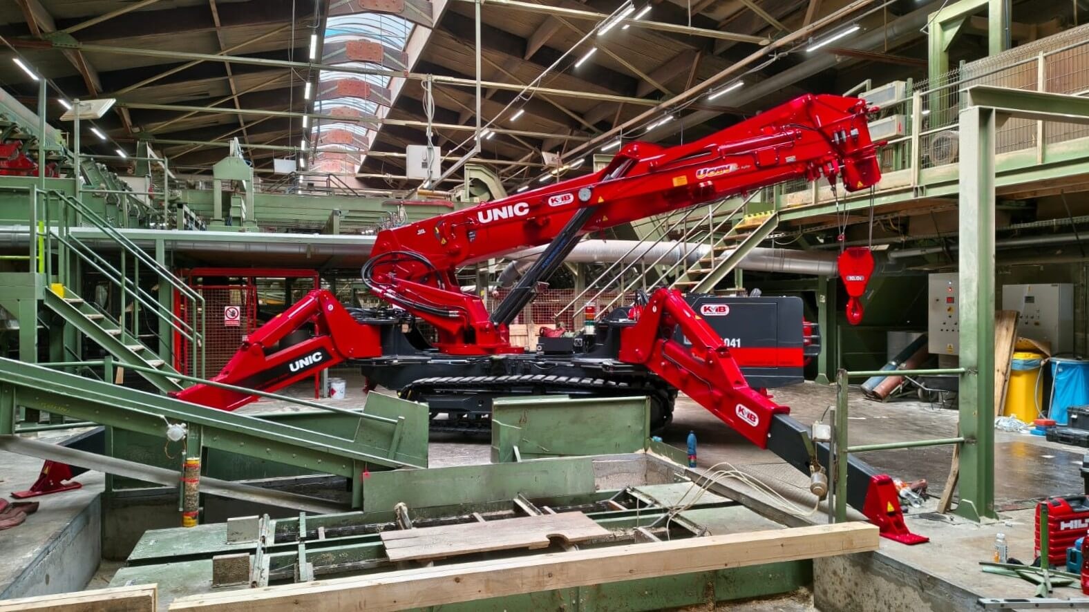 UNIC URW-1006 mini spider crane installing sawdust sorting line components inside a Czech pallet production hall