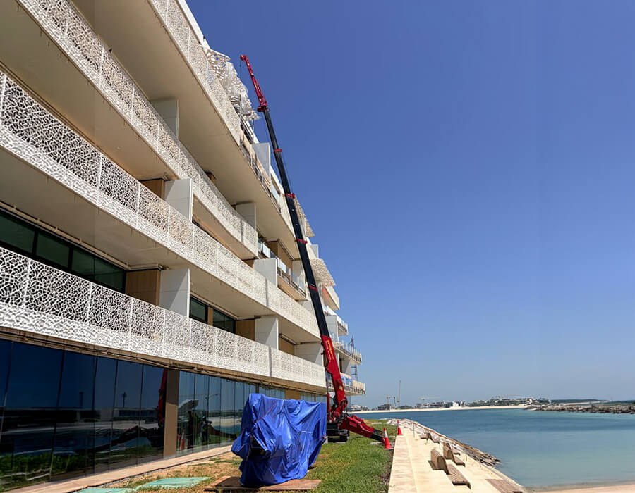 UNIC URW-706-2 spider crane with fly jib working on the beachfront façade of the BVLGARI Resort in Dubai