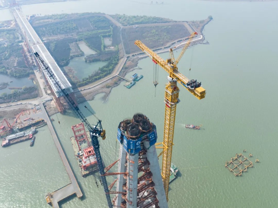 Aerial view of tower cranes working on the 350-metre main tower of the Changtai Yangtze River Bridge