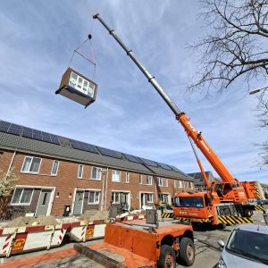 Grove GMK4100L-2 all-terrain crane lifting a prefab home extension over a house in Alkmaar, the Netherlands