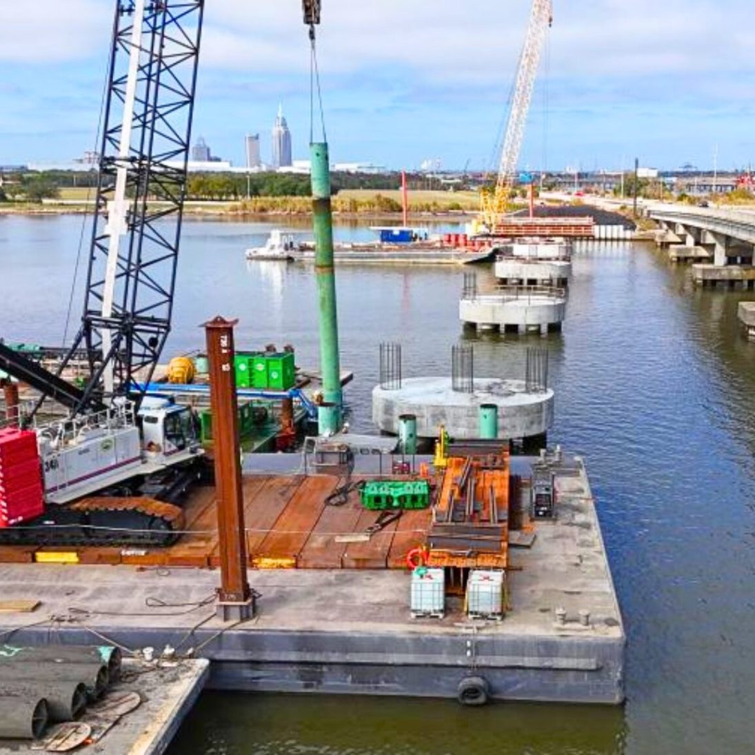 Barge-mounted Link-Belt lattice crawler crane driving piles for the Tensaw River Bridge replacement near Mobile, Alabama