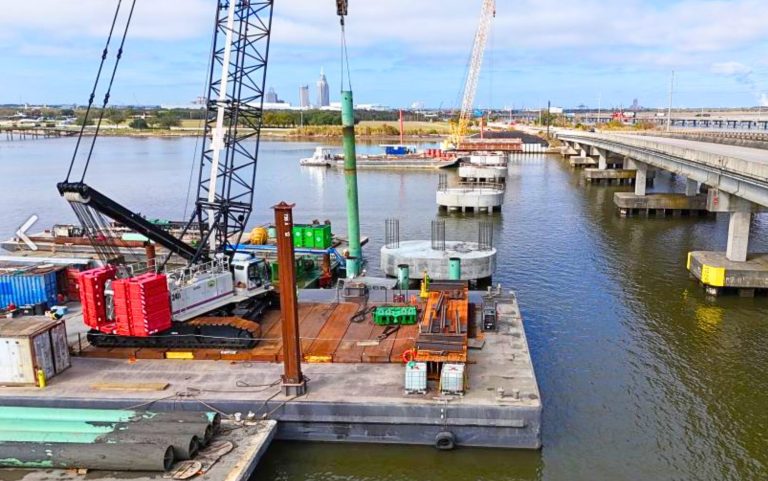 Barge-mounted Link-Belt lattice crawler crane driving piles for the Tensaw River Bridge replacement near Mobile, Alabama