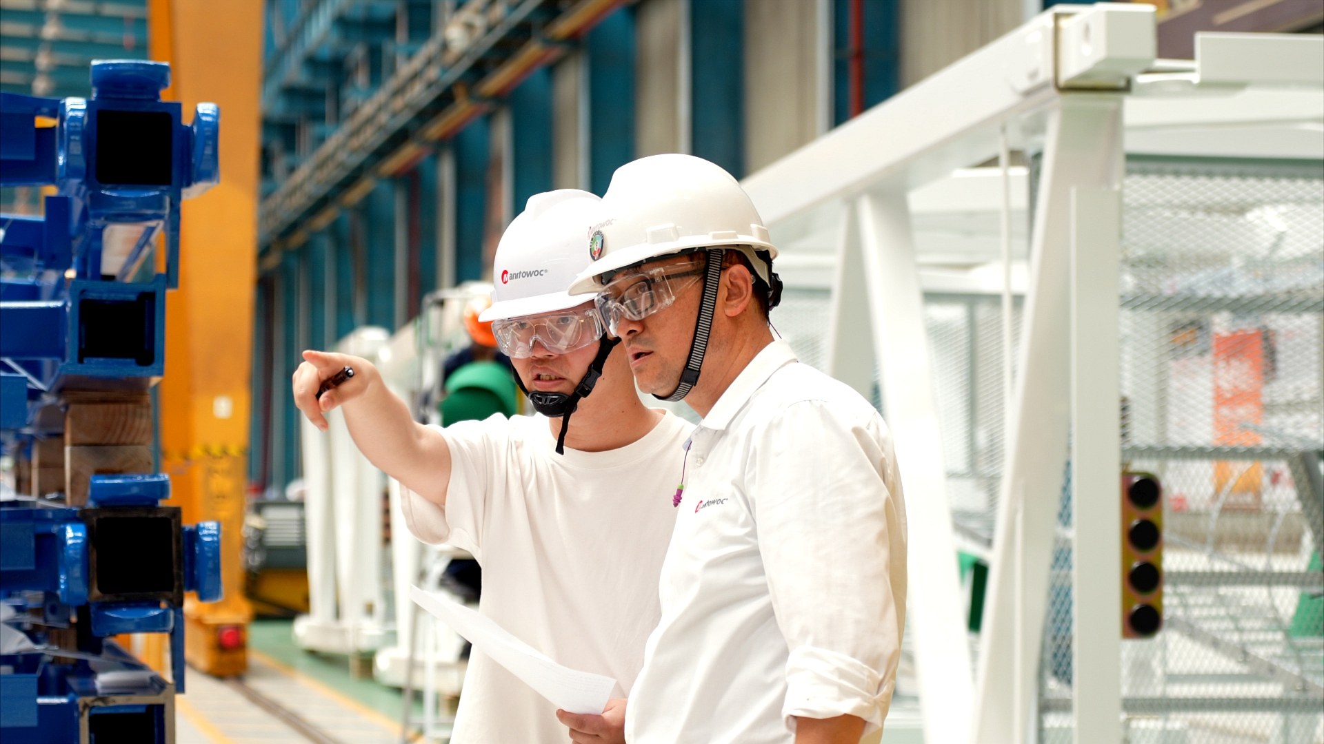 Production staff review tower crane components at the Potain factory in Zhangjiagang
