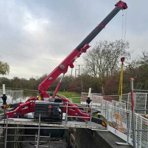 Unic URW-706 mini spider crane rigged over the drained lock chamber during the gate replacement