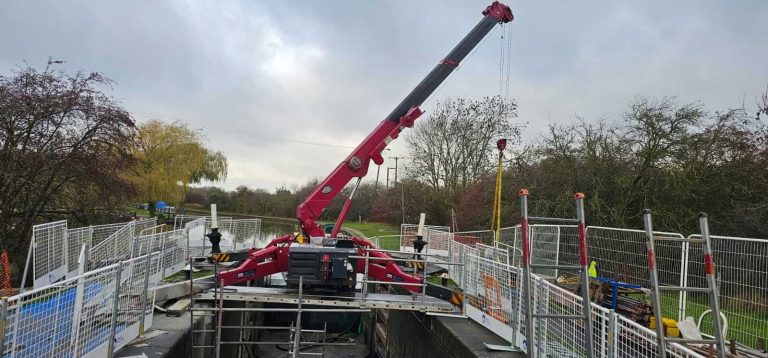 Unic URW-706 mini spider crane rigged over the drained lock chamber during the gate replacement