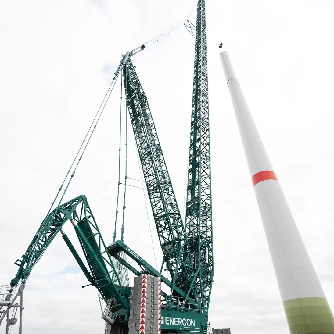 The Enercon Liebherr LR 11000 crawler crane rigged with the SL12 boom system beside a wind turbine tower section