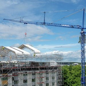 Liebherr MK 88-4.1E mobile construction crane lifting canopy sections between residential blocks in Uppsala