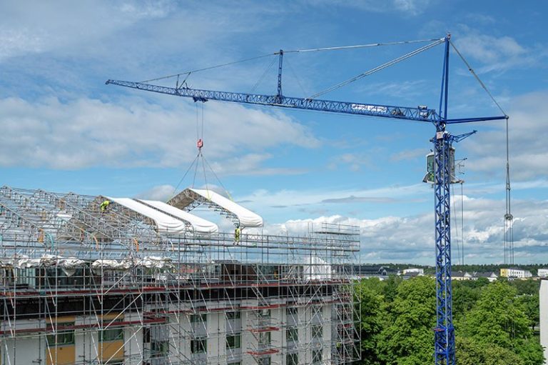 Liebherr MK 88-4.1E mobile construction crane lifting canopy sections between residential blocks in Uppsala