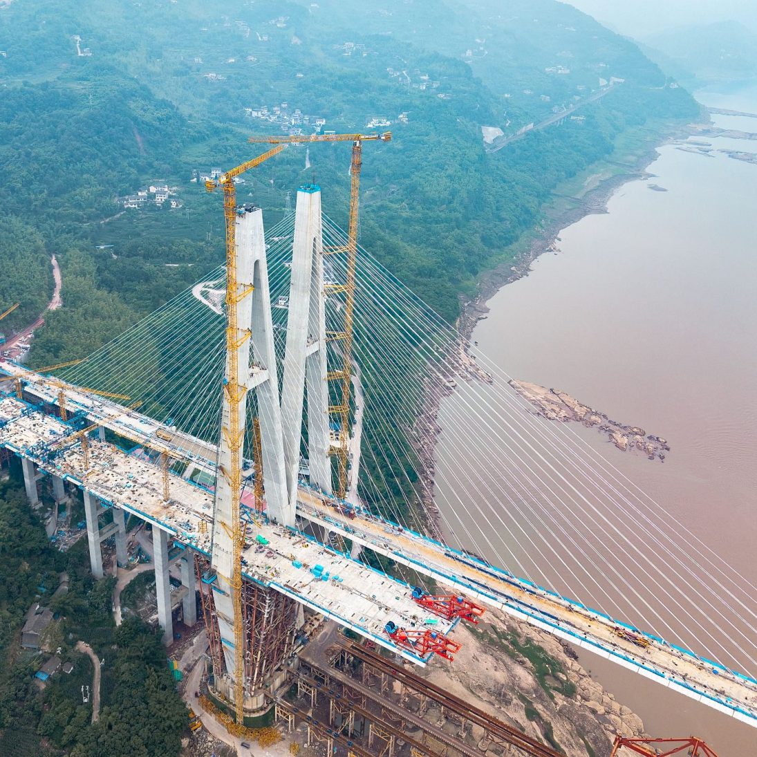 Potain MCT 560 M25 topless tower cranes on the south tower of the Shituo Yangtze River Bridge in Chongqing, China