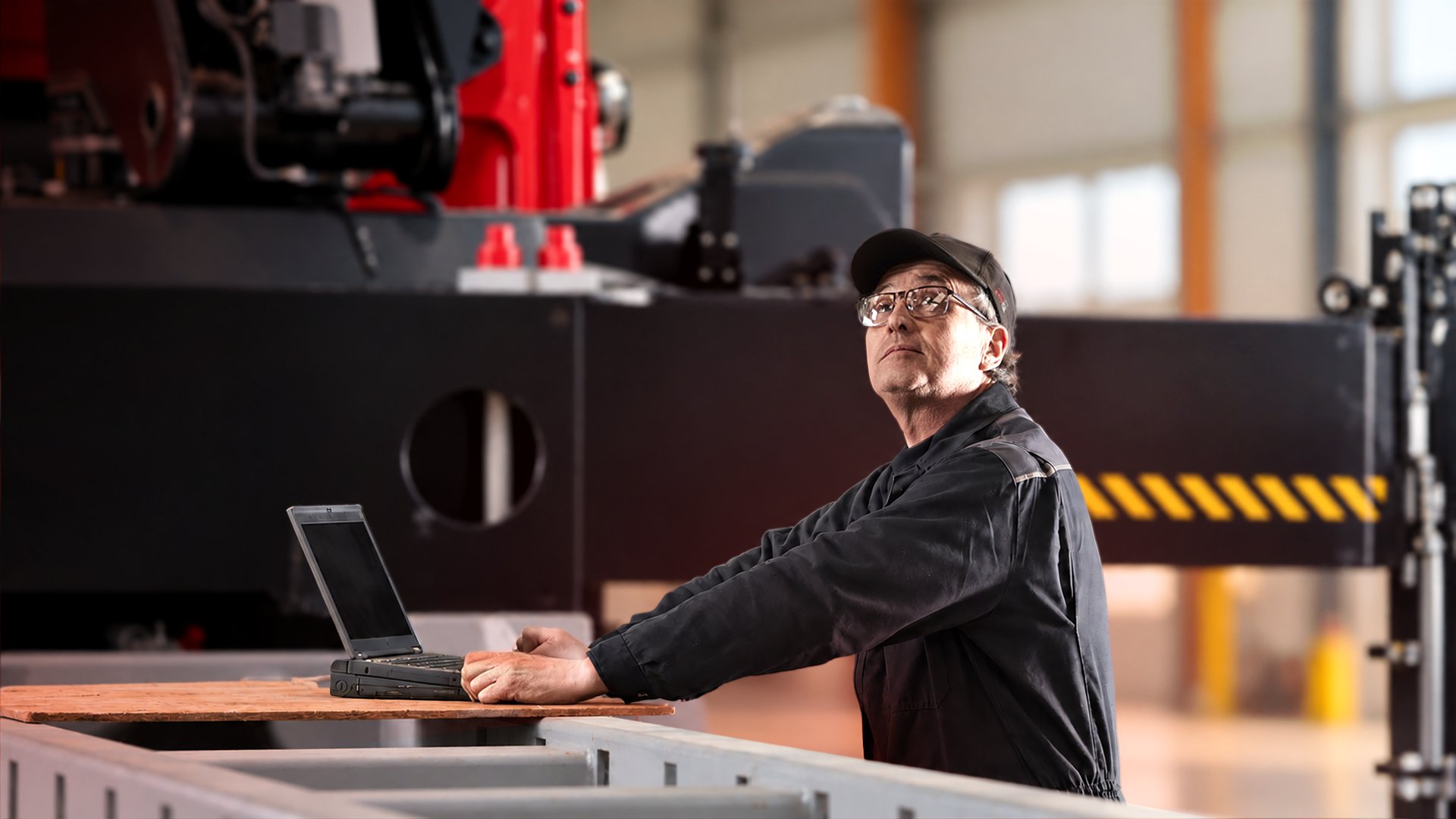 Service technician with laptop beside a Hiab loader crane in a workshop, illustrating ProCare lifecycle services