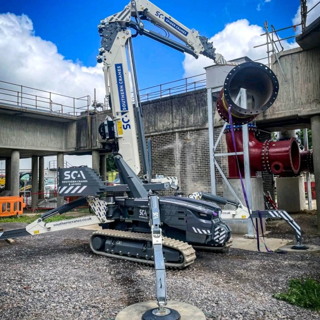 Hoeflon spider crane of Southern Cranes & Access lifting a large pipe section at an industrial site