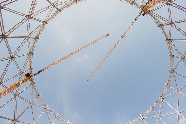Three Liebherr EC-B flat-top tower cranes over the Bovisa gasometer site in Milan