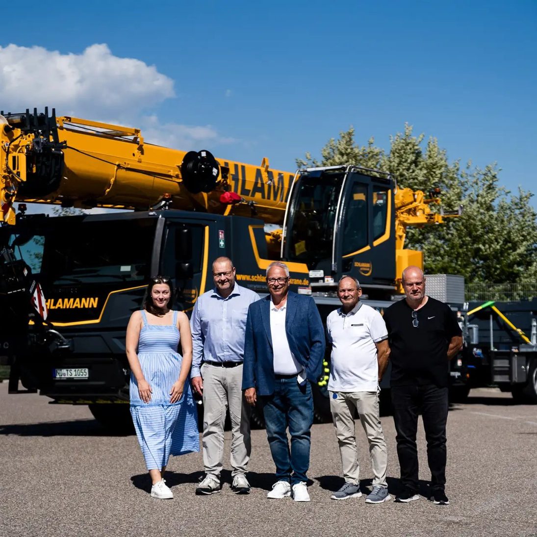 Liebherr LTM 1055-3.3 mobile crane handover to Schlamann-Autokrane, with representatives of both companies in front of the new 55-tonne all-terrain crane
