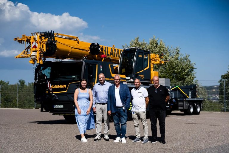 Liebherr LTM 1055-3.3 mobile crane handover to Schlamann-Autokrane, with representatives of both companies in front of the new 55-tonne all-terrain crane