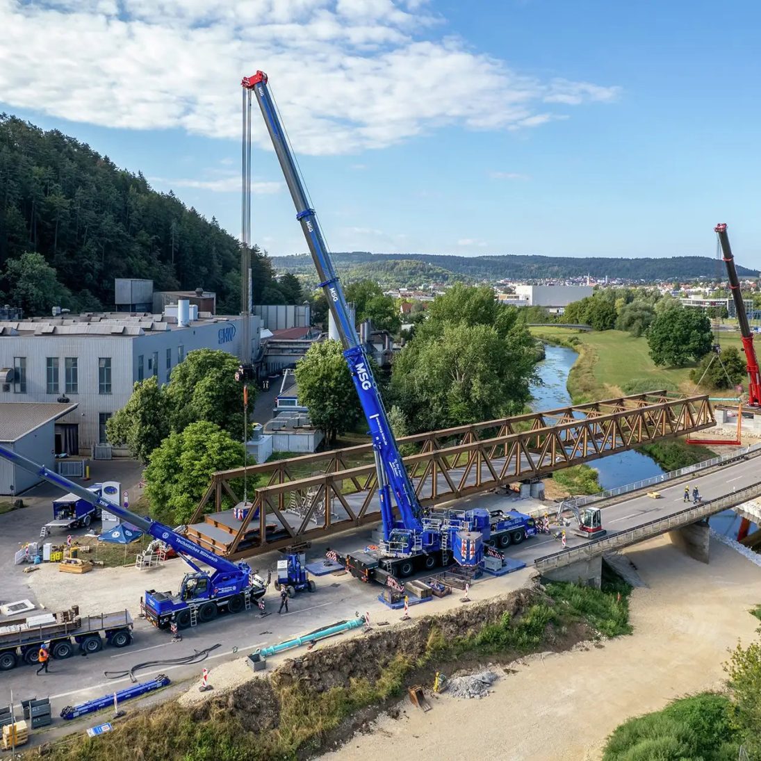 Two Liebherr LTM 1650-8.1 mobile cranes lifting the 70-metre temporary bridge across the Danube in tandem