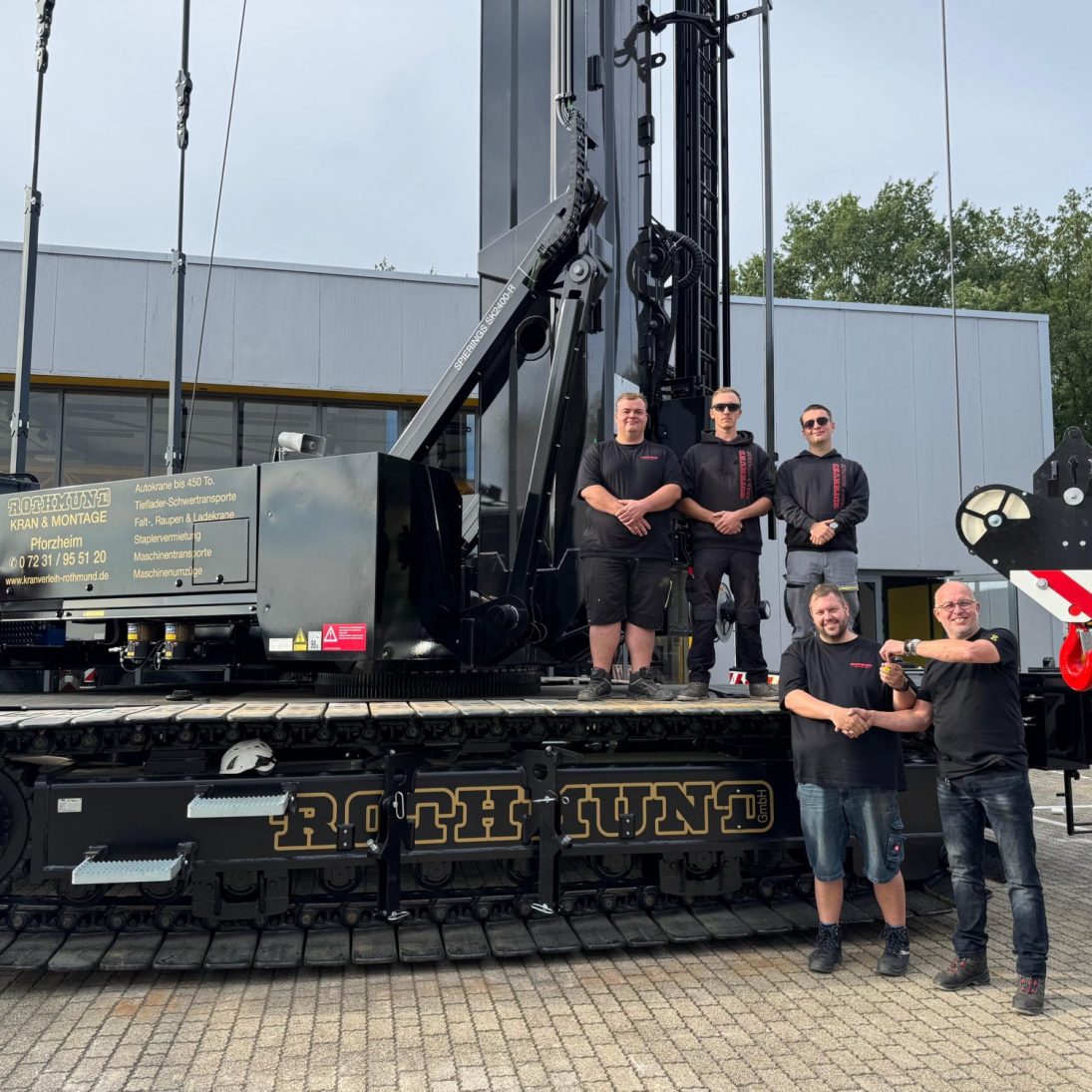 Spierings SK2400-R eLift crawler-mounted tower crane in black Rothmund GmbH livery at the key handover